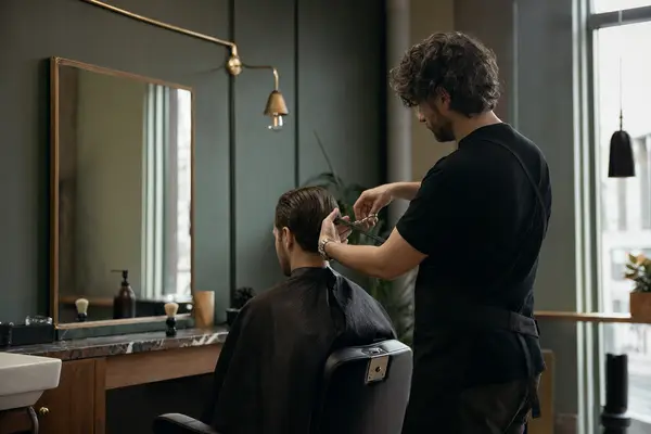 Friseur schneidet einem Gast am Spiegelplatz die Haare